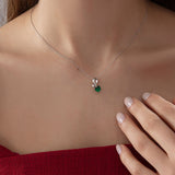 Heart Emerald Necklace with Diamond Swirl in silver, worn